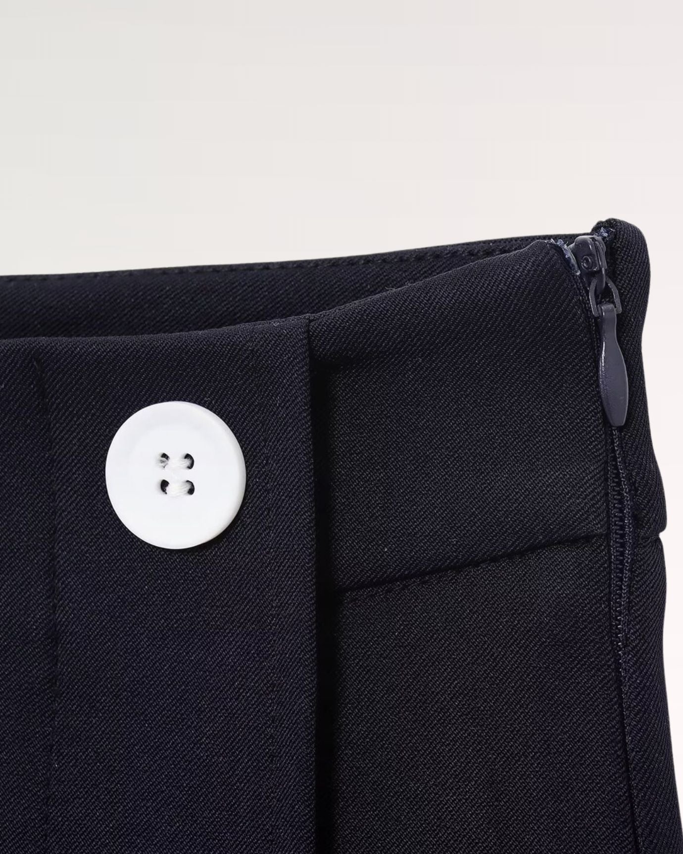 Hidden zipper at the rear waist ensuring a clean, uninterrupted silhouette