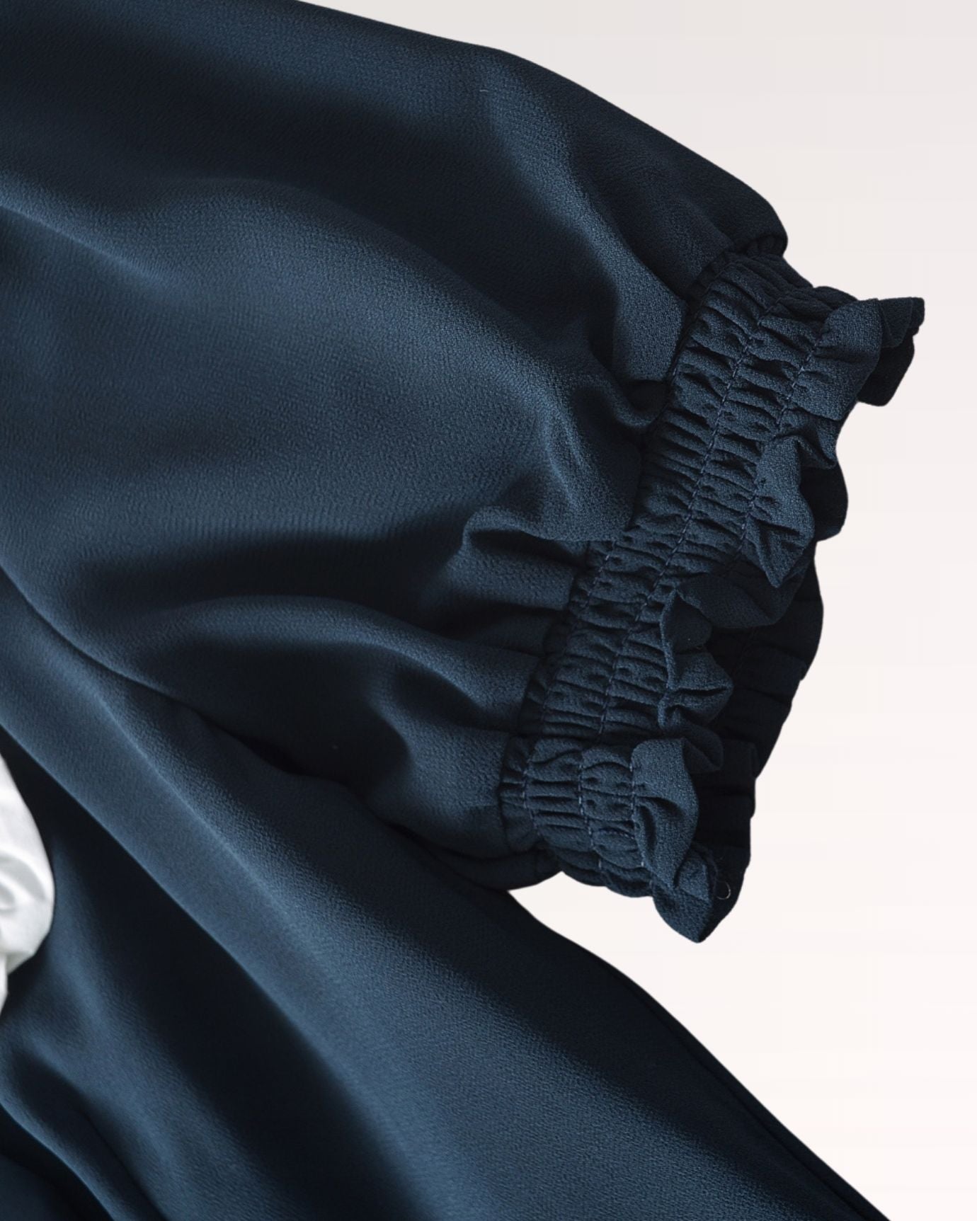 Short sleeve design with gentle gathers, complementing the flowing fabric of the dress