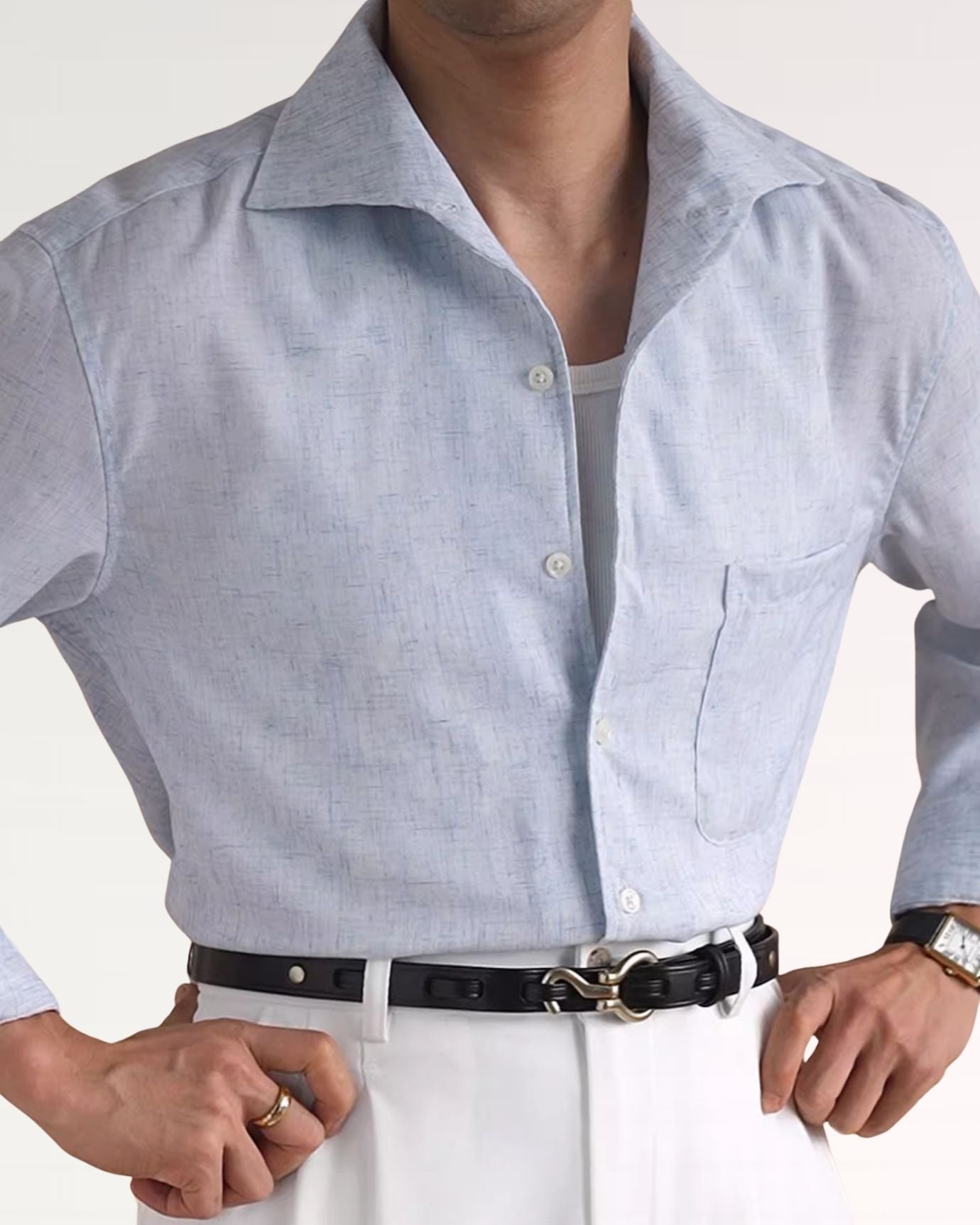 Man wearing a light blue button-up shirt with a white background