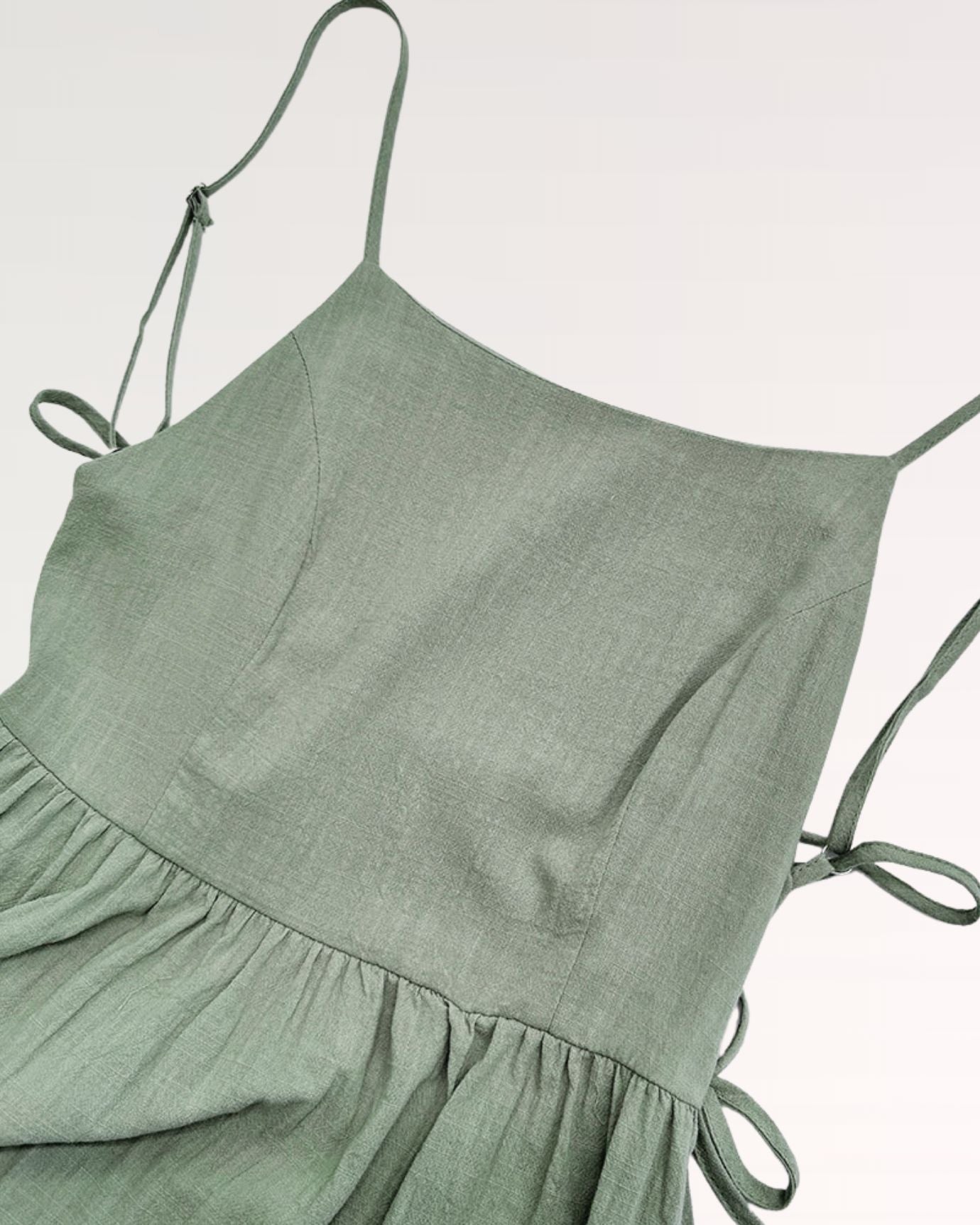 Stylish suspender dress in light green, with button details on the front straps