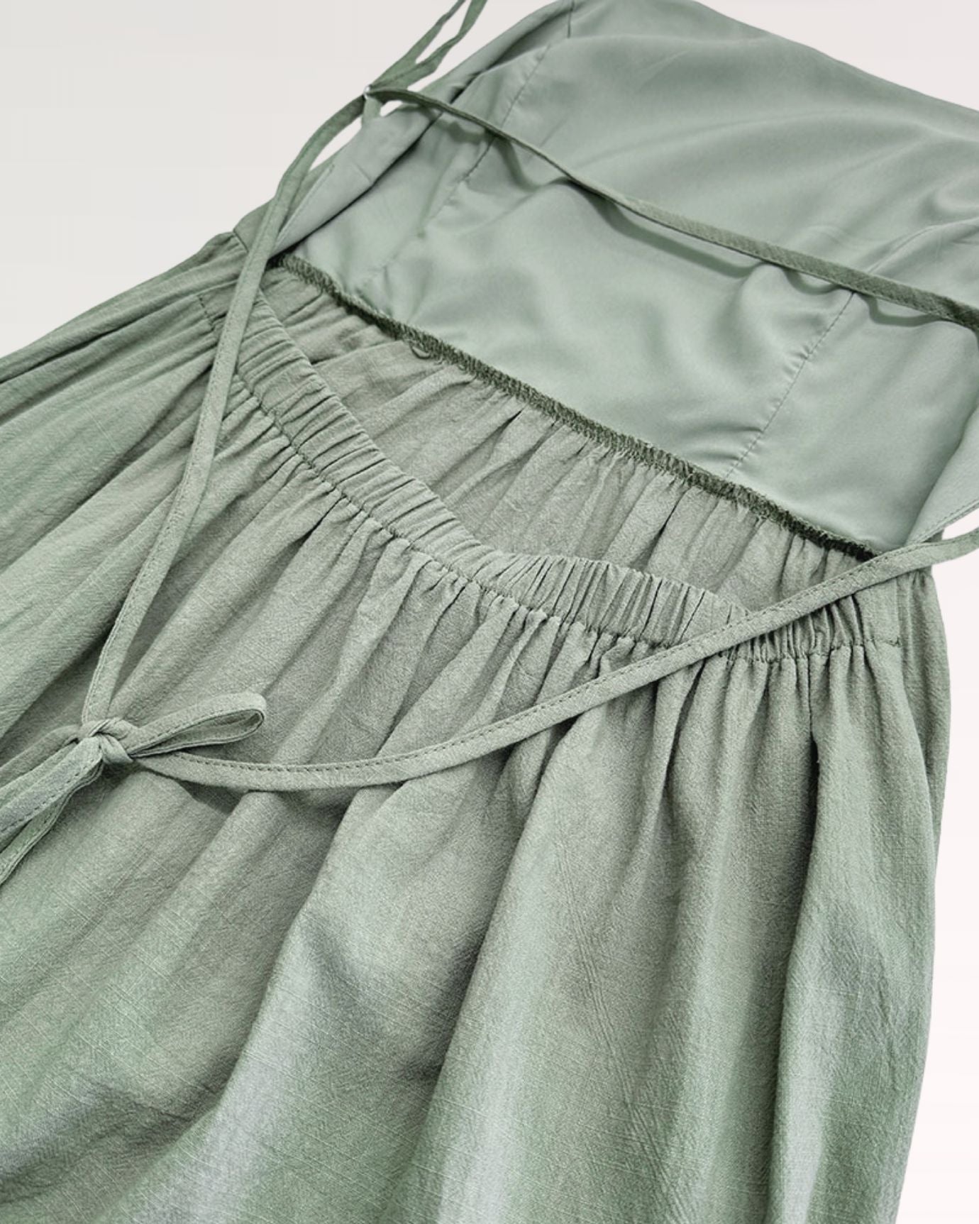 Light green Rhi suspender dress with adjustable shoulder straps and a flowy silhouette