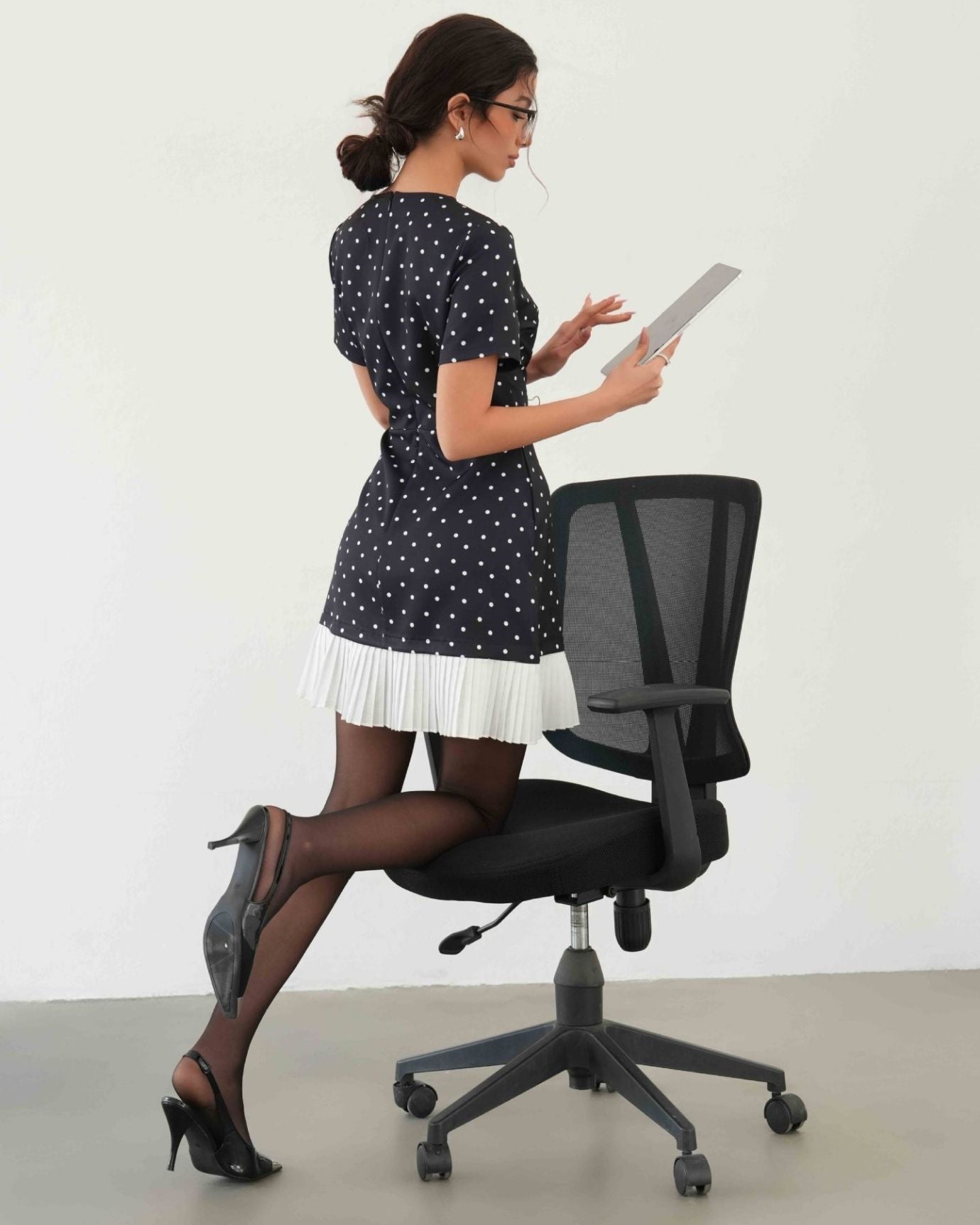 Back view of sleeveless Polkadot Ice Silk Dress in black with subtle polka dot design