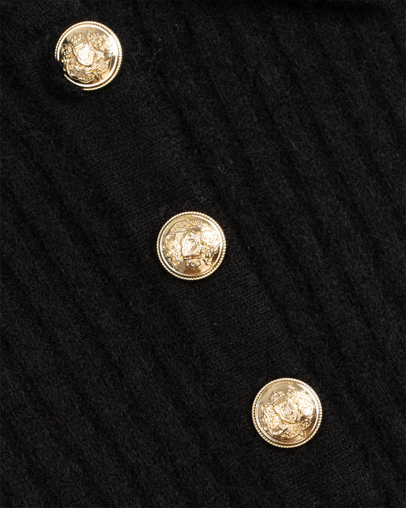 Close-up of a black fabric surface with gold buttons
