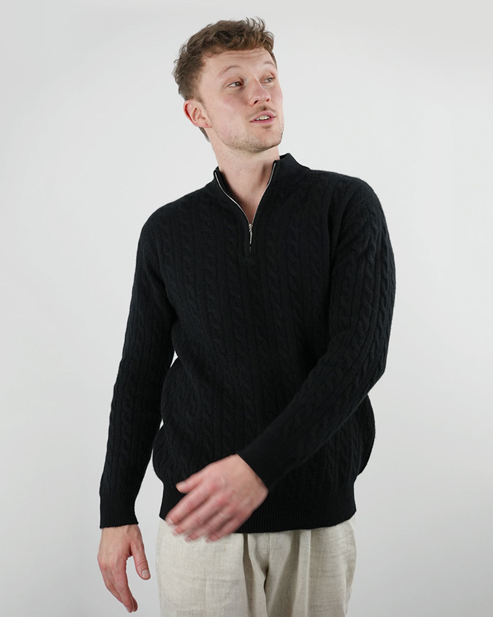 Man wearing a black sweater against a plain background