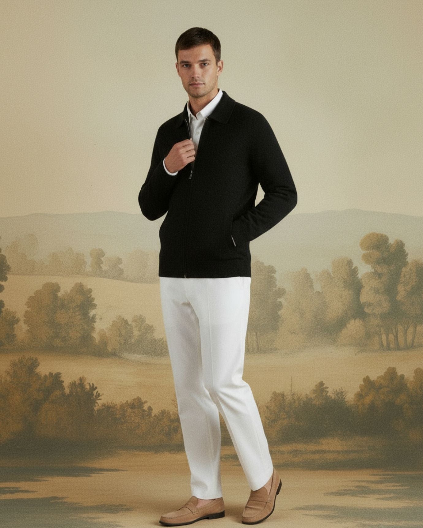 Man wearing a black sweater and white pants standing in front of a scenic wall mural.
