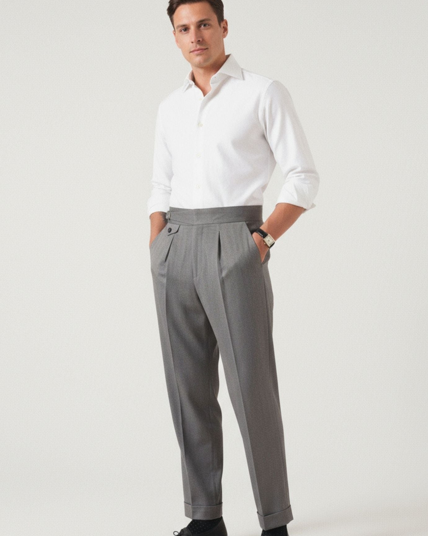 Man wearing a white shirt and gray pants on a plain background