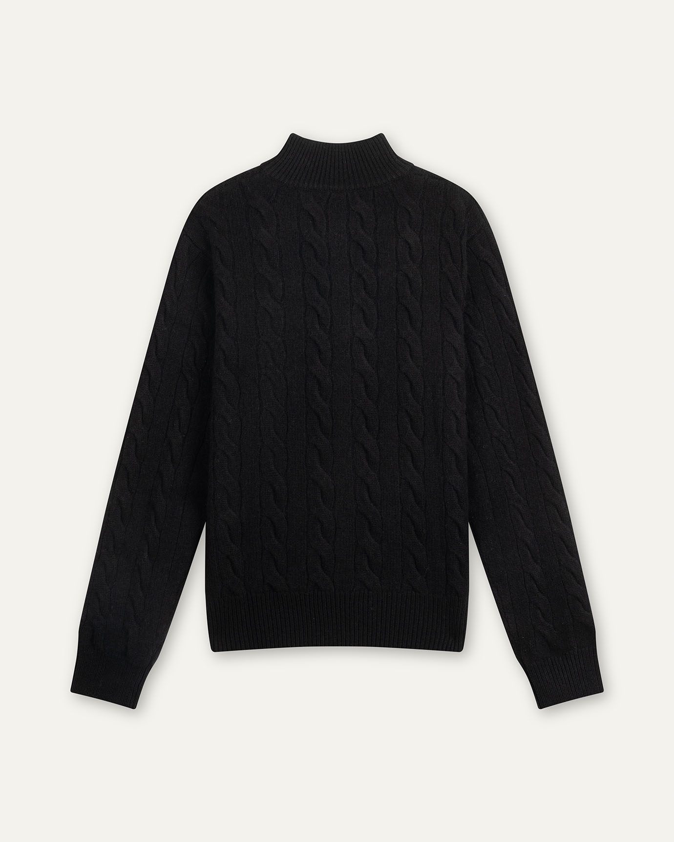 Black cable knit sweater on a light gray background
