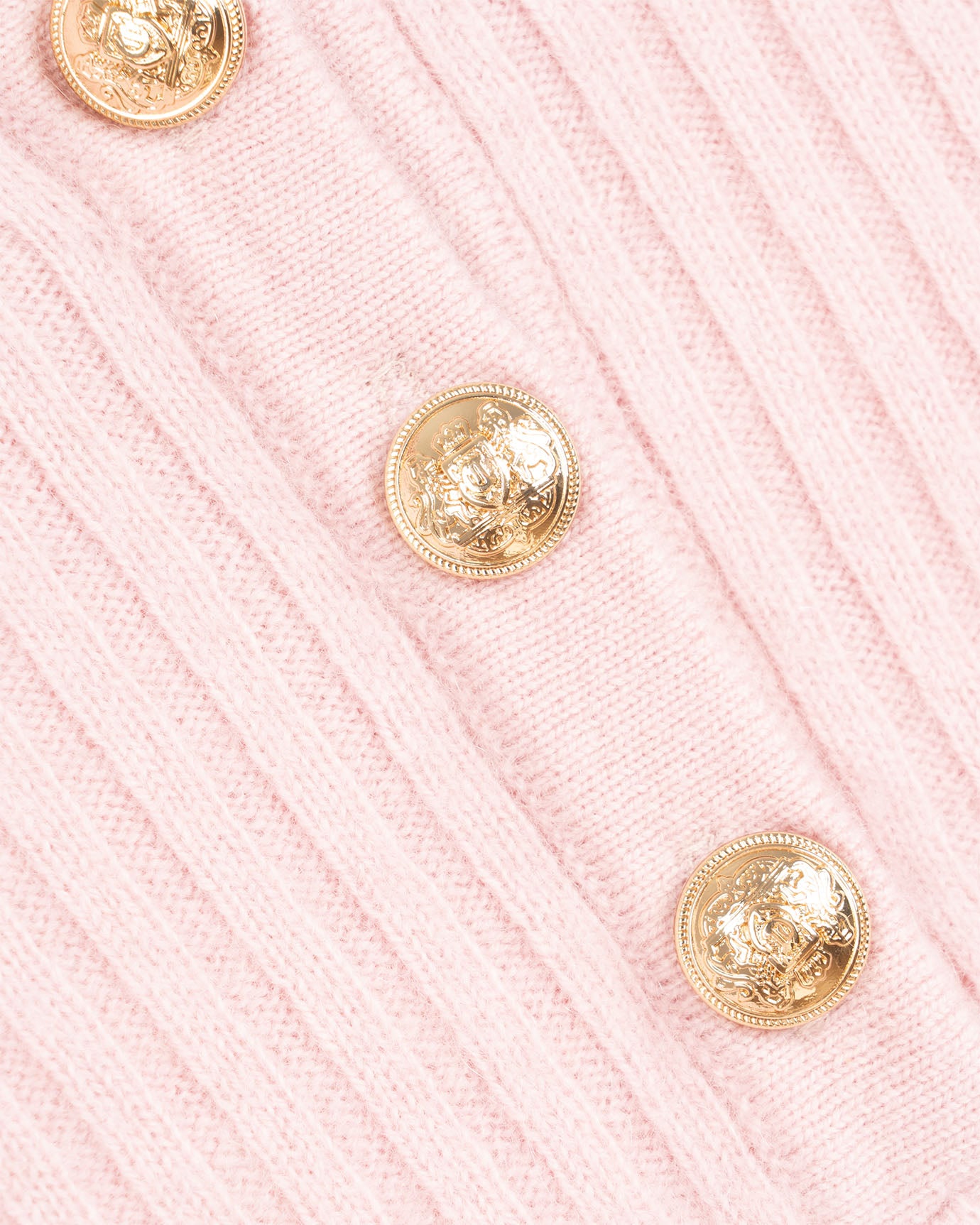 Close-up of pink textured fabric with gold buttons