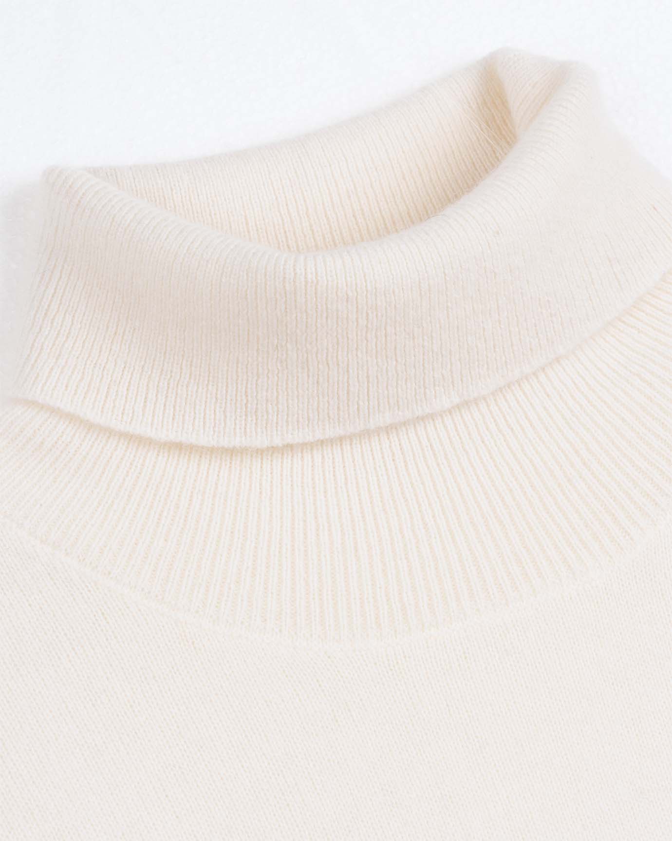 Close-up of soft knit texture on white turtleneck sweater